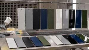 Powder-coated and painted metal sample panels arranged in a fabrication finishing area.